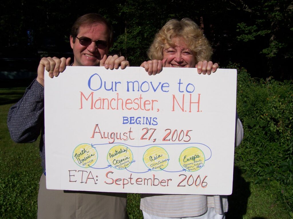 Rob, Marilyn with sign saying we were moving east by traveling westward