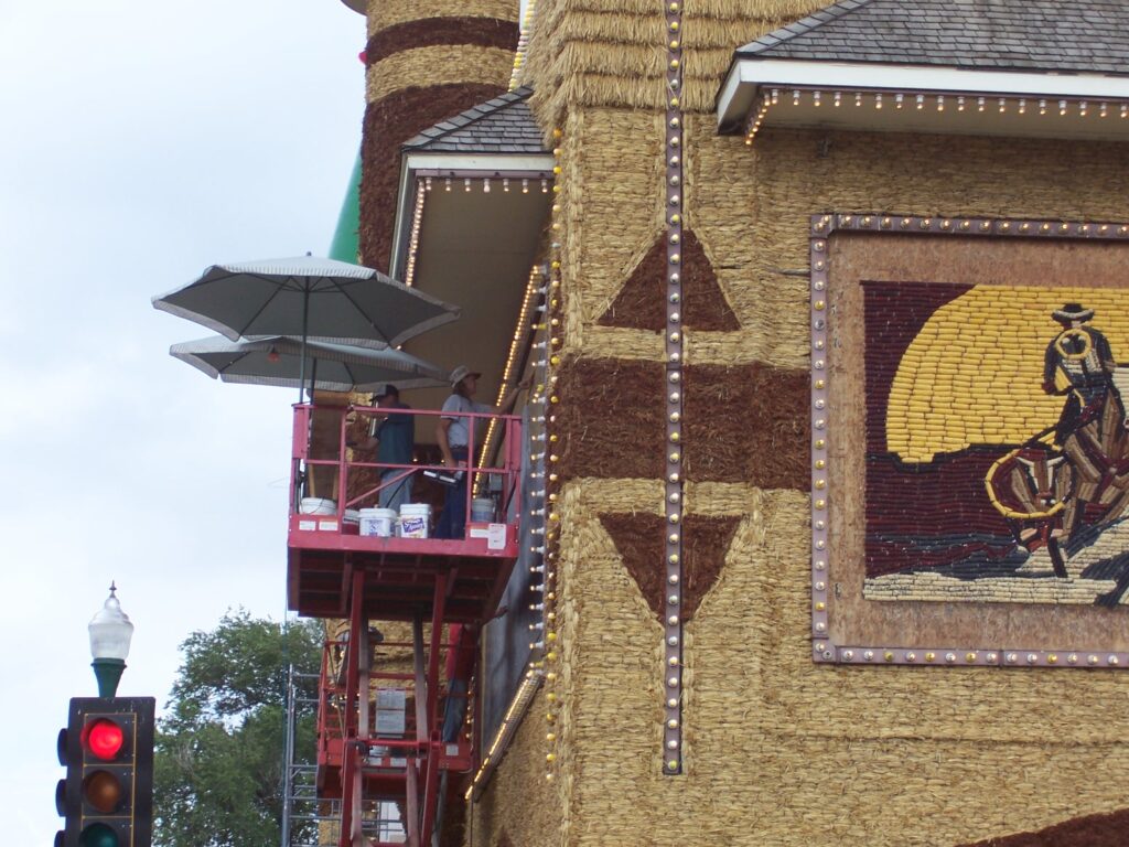 Workers putting up corn to decorate the front of the building