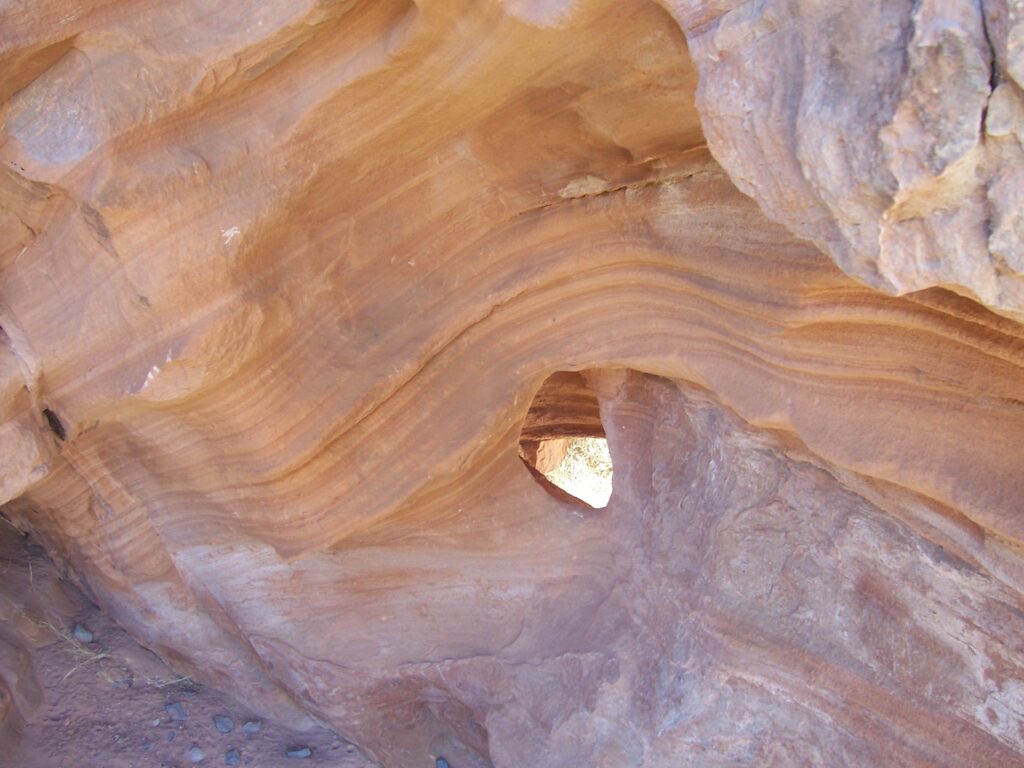 photo-AZ-wind-hole-cut-through-striated-red-rock